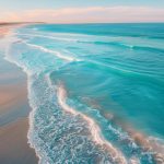 A stunning coastal view of one of the best beaches for Melbourne residents, showcasing golden sand, blue waves, and a relaxing beach atmosphere.