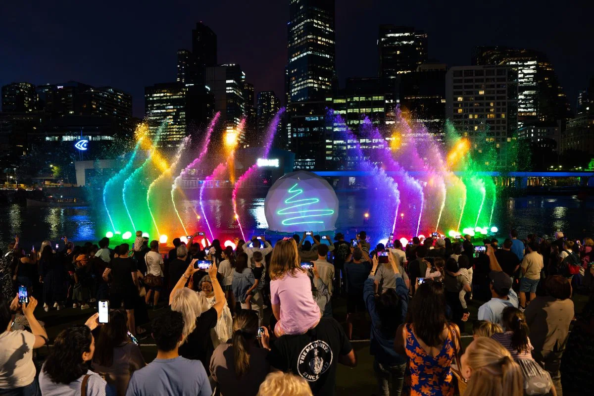 Families enjoying the Crown Christmas River Show with lasers, fountains, and festive lights along the Yarra River in Melbourne